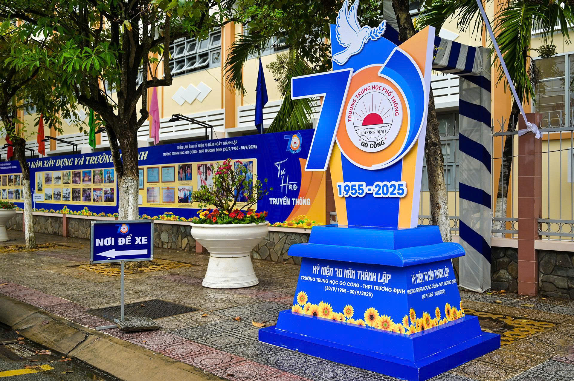 Biểu tượng số 70 màu xanh lớn kỷ niệm 70 năm ngày thành lập trường Trung học Gò Công - THPT Trương Định (1955-2025) đặt trên vỉa hè trước sân trường.